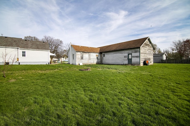 back of house featuring a yard and fence