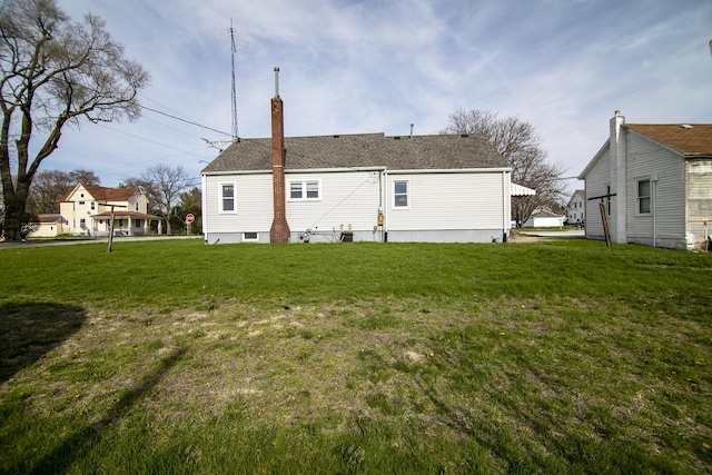 rear view of house with a lawn and a chimney