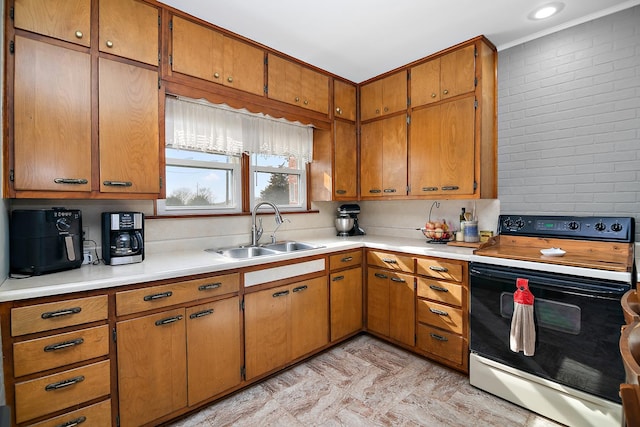 kitchen with light countertops, electric range, ornamental molding, and a sink