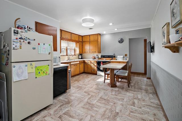 kitchen featuring crown molding, a sink, brown cabinetry, white appliances, and light countertops