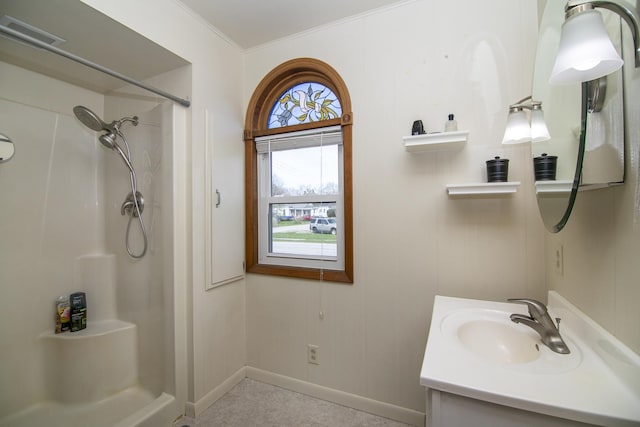 bathroom with baseboards, walk in shower, vanity, and visible vents