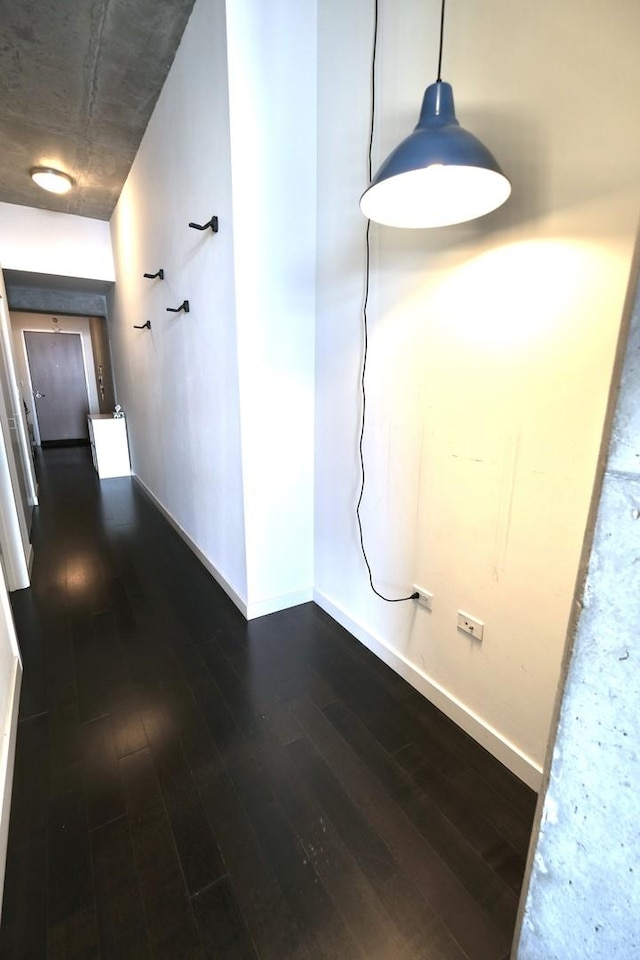 hallway featuring baseboards and dark wood-style floors