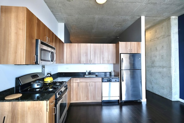 kitchen with a sink, appliances with stainless steel finishes, modern cabinets, and dark wood-style floors