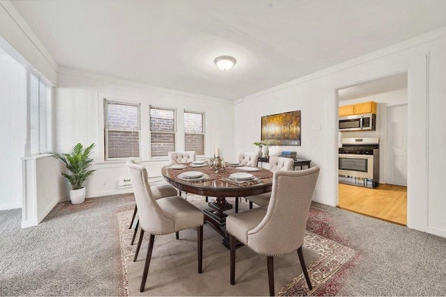 dining room featuring light colored carpet and ornamental molding