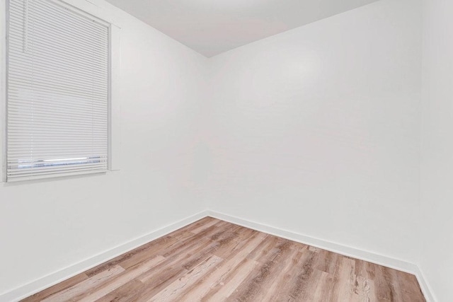 empty room featuring baseboards and light wood-type flooring