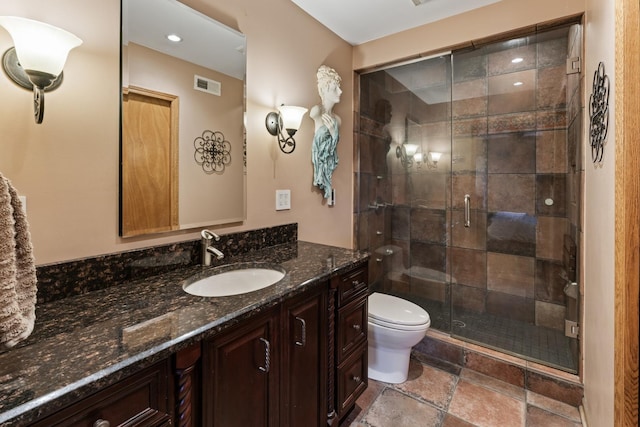 full bath with visible vents, stone tile flooring, toilet, a shower stall, and vanity