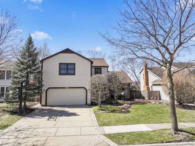 traditional-style house featuring driveway, fence, an attached garage, and a front lawn