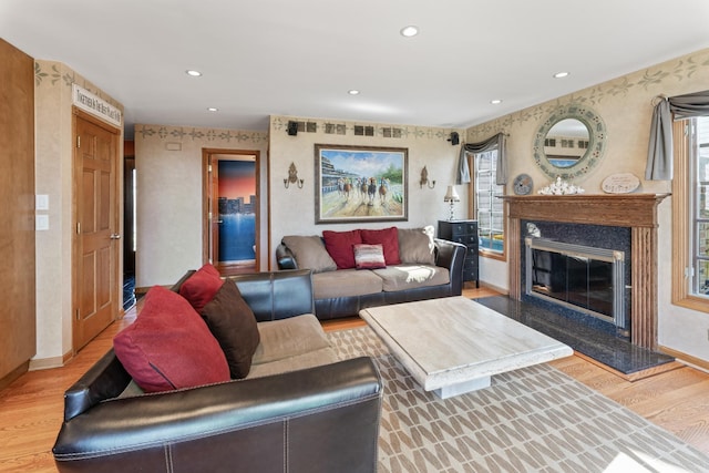 living area with plenty of natural light, baseboards, wallpapered walls, and wood finished floors