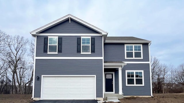 traditional-style house with entry steps, a garage, and aphalt driveway