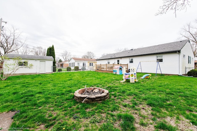 536 Evergreen Ln, Bradley, IL 60915 - view of yard featuring a fire pit, an outbuilding, fence, and a playground