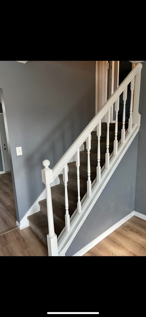staircase with baseboards and wood finished floors