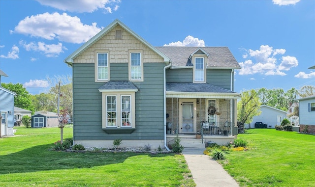 view of front of house featuring a porch, a shingled roof, and a front lawn