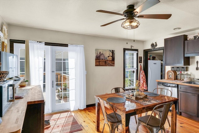 dining area with a ceiling fan and light wood-style floors