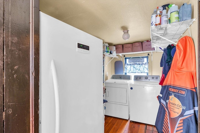 clothes washing area featuring washer and dryer, laundry area, and hardwood / wood-style floors