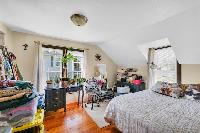 bedroom with lofted ceiling and hardwood / wood-style flooring