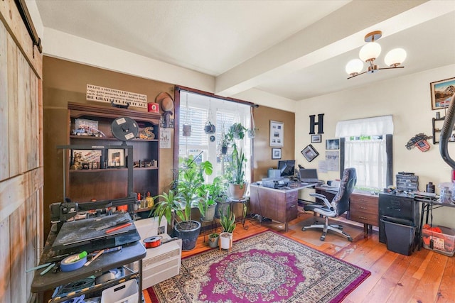 home office with beamed ceiling, an inviting chandelier, and hardwood / wood-style flooring