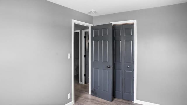 unfurnished bedroom with light wood-style floors, a closet, and baseboards