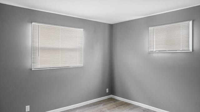 unfurnished room featuring baseboards and wood finished floors
