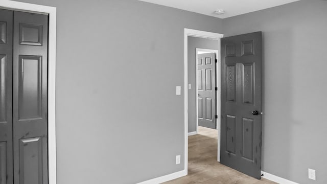unfurnished bedroom featuring light wood-style floors and baseboards