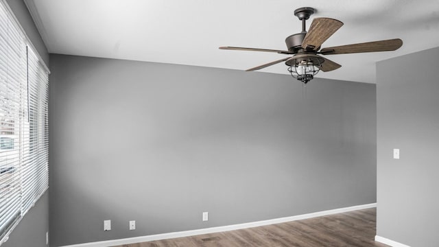 spare room featuring wood finished floors, ceiling fan, and baseboards
