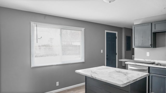 kitchen with light countertops, a center island, dishwasher, and gray cabinetry