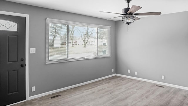 foyer entrance featuring wood finished floors, ceiling fan, baseboards, and visible vents