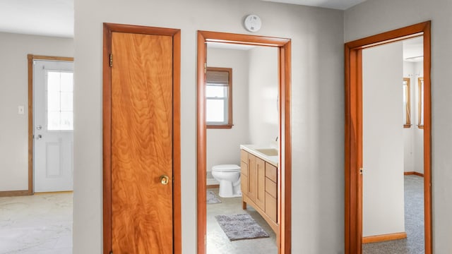 bathroom featuring toilet, a wealth of natural light, vanity, and baseboards