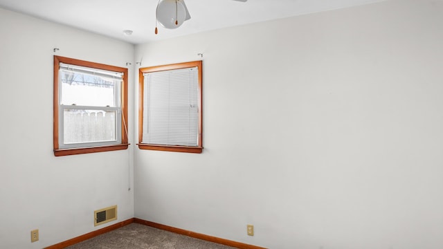 spare room with ceiling fan, baseboards, carpet flooring, and visible vents