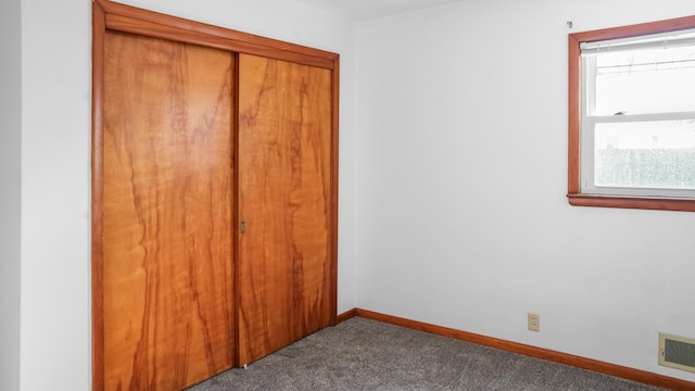 unfurnished bedroom with a closet, baseboards, carpet, and visible vents