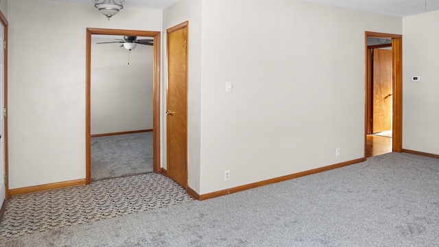 carpeted spare room with baseboards and a ceiling fan