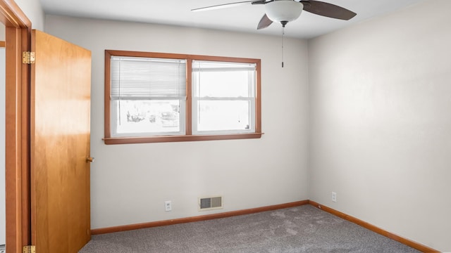 empty room with visible vents, ceiling fan, carpet floors, and baseboards