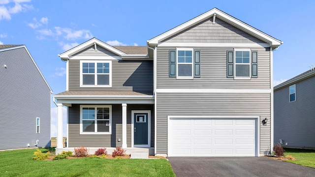 craftsman inspired home with a front yard, an attached garage, covered porch, and aphalt driveway