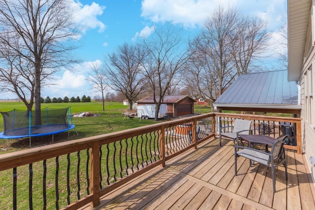10690 E 1700 N Rd, Pontiac, IL 61764 - deck featuring an outbuilding, a trampoline, a yard, and a garage