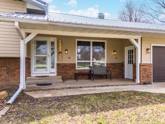 10690 E 1700 N Rd, Pontiac, IL 61764 - entrance to property with brick siding, a porch, a garage, and metal roof