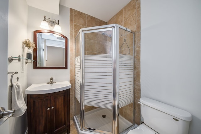 full bathroom featuring vanity, a shower stall, and toilet