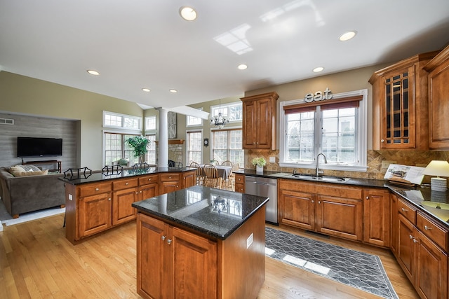 kitchen with a center island, ornate columns, brown cabinets, a sink, and dishwasher
