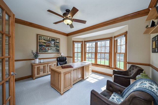 office space with baseboards, ornamental molding, light carpet, and a ceiling fan