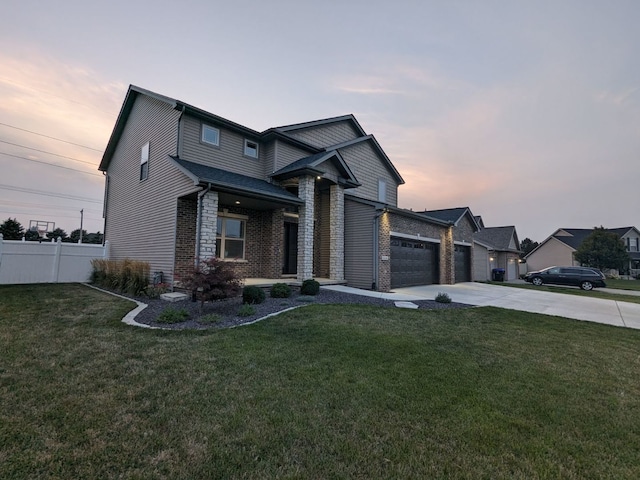 2110 Escalade Rd, Bloomington, IL 61705 - view of front facade featuring driveway, a front lawn, brick siding, a garage, and fence
