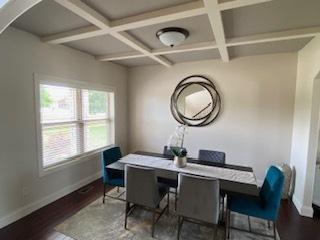 2110 Escalade Rd, Bloomington, IL 61705 - dining area featuring baseboards, beamed ceiling, coffered ceiling, arched walkways, and wood finished floors