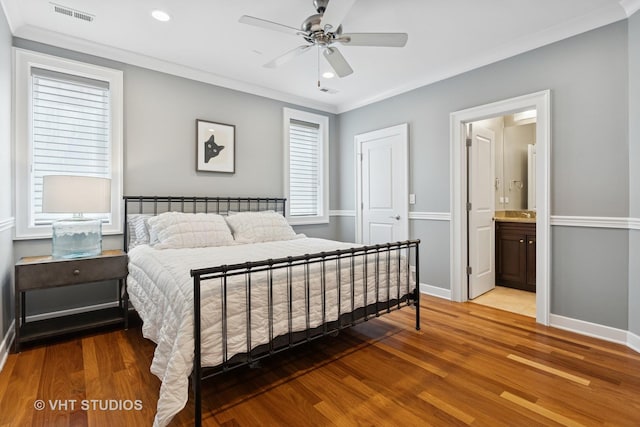 bedroom featuring wood finished floors, ornamental molding, baseboards, recessed lighting, and connected bathroom