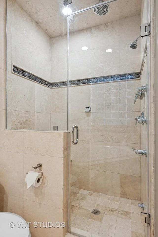 full bathroom with a shower stall and toilet
