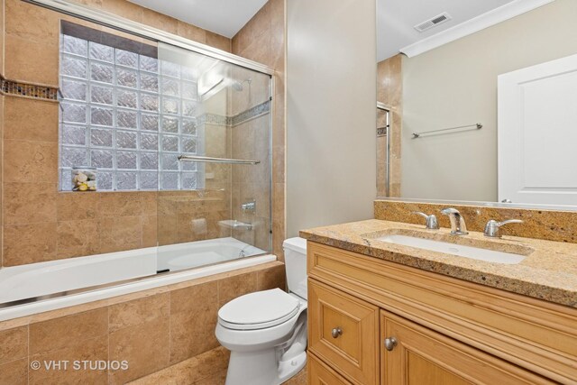 bathroom with toilet, tiled shower / bath combo, vanity, crown molding, and tile patterned floors