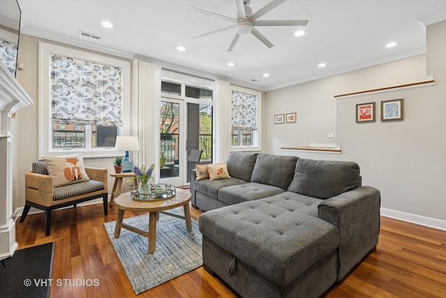 living area with a ceiling fan, wood finished floors, recessed lighting, baseboards, and ornamental molding