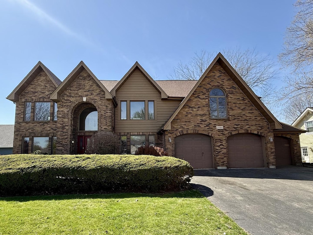 2060 Carolyn Rd, Aurora, IL 60506 - view of front facade featuring an attached garage, brick siding, driveway, and a front yard