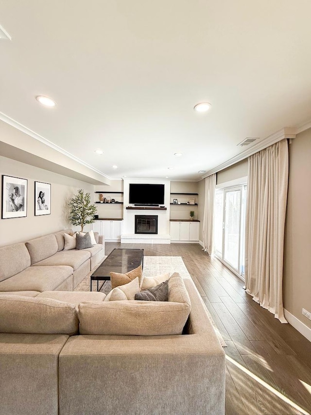living room with crown molding, baseboards, recessed lighting, and wood finished floors