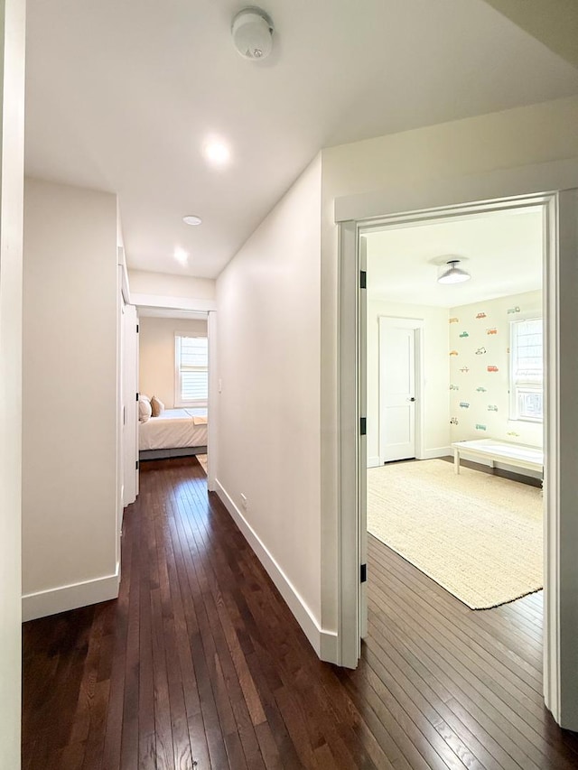 corridor with recessed lighting, baseboards, and dark wood finished floors