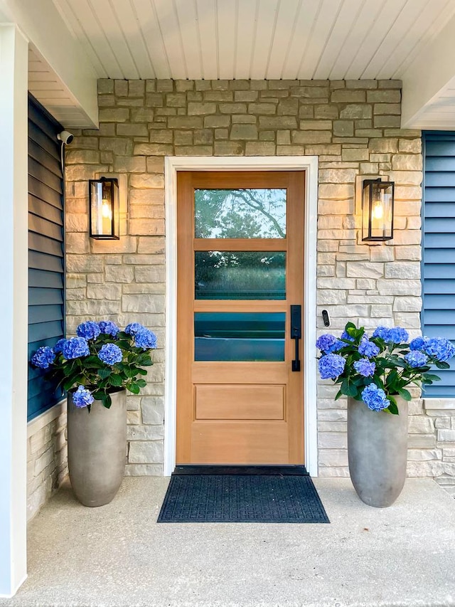 doorway to property with stone siding