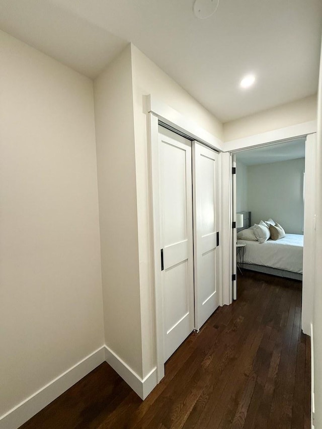 corridor featuring recessed lighting, baseboards, and dark wood-style floors