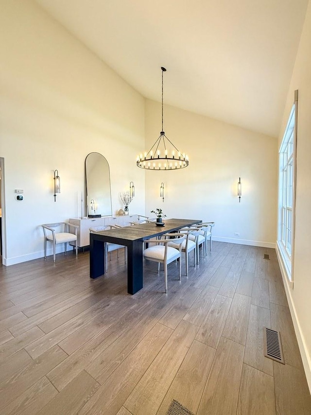 dining area featuring a chandelier, baseboards, visible vents, and wood finished floors