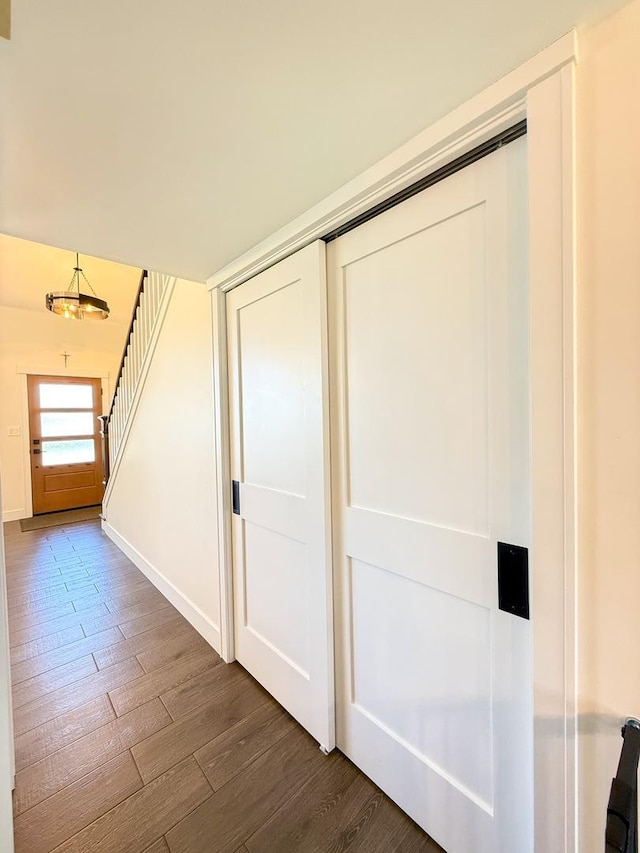 interior space featuring baseboards, dark wood finished floors, and stairs